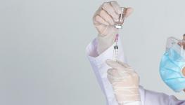 young-doctor-is-holding-hypodermic-syringe-with-vaccine-vial-rubber-gloves-gray-wall.jpg