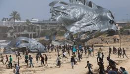 فلسطينيون يركضون لالتقاط مساعدات أُسقطت جواً في دير البلح .jpg